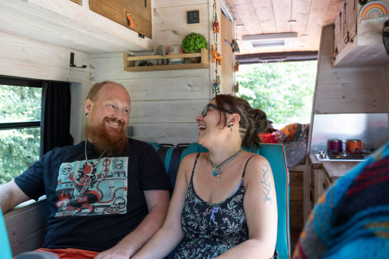 Marie and Matt from Wild River Campers sitting together inside their bespoke campervan.