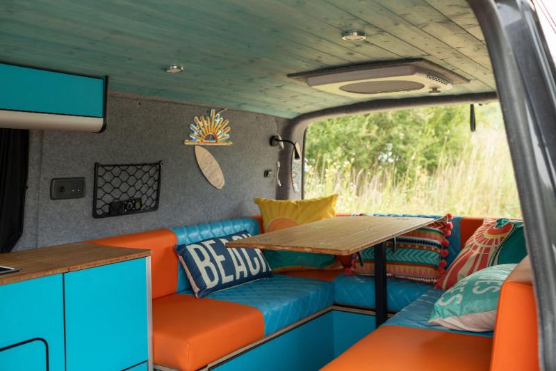 Roxy: Orange and blue seating area inside the Roxy campervan